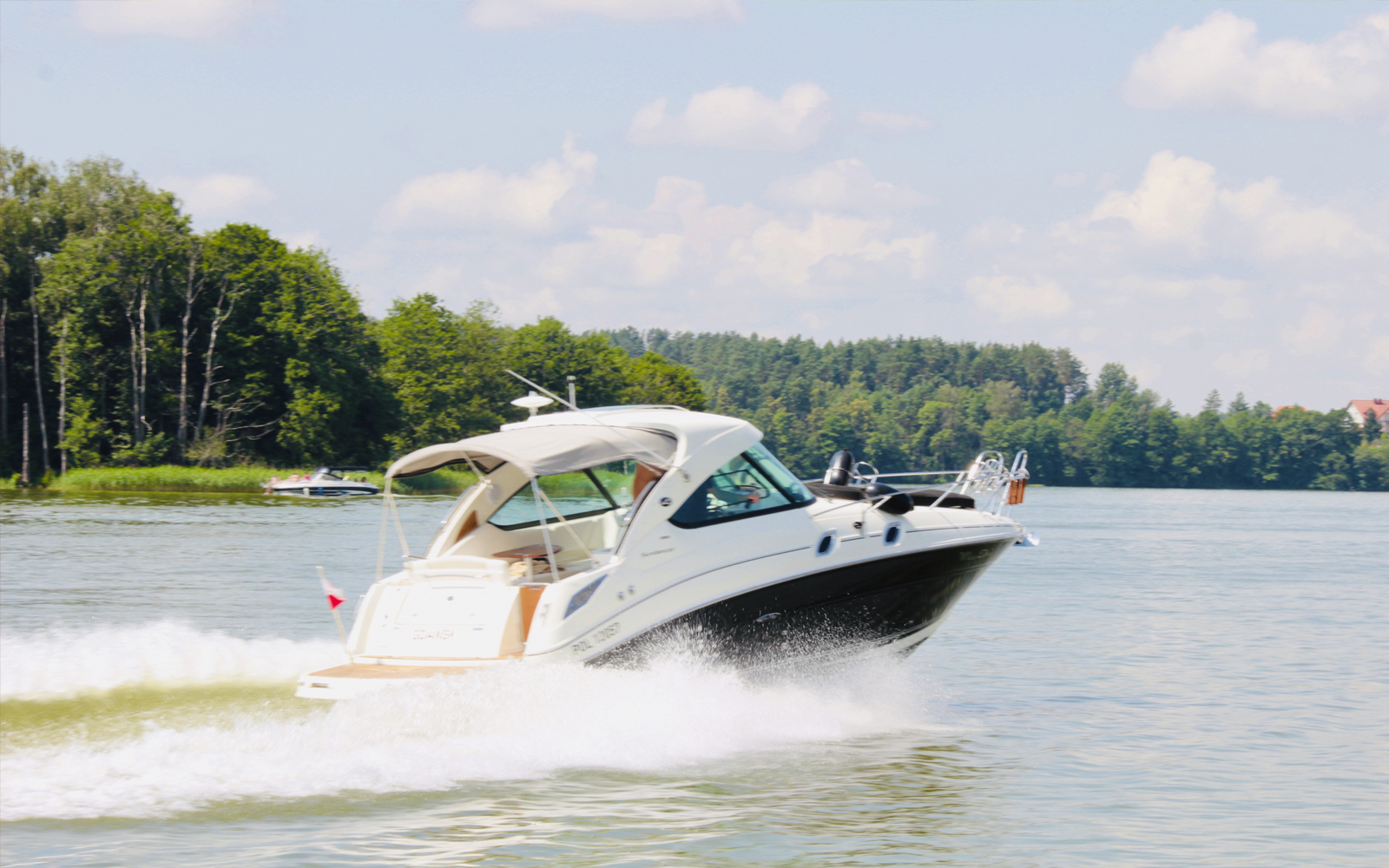 kleines Motorboot fährt in einem großen See bei guten Wetter