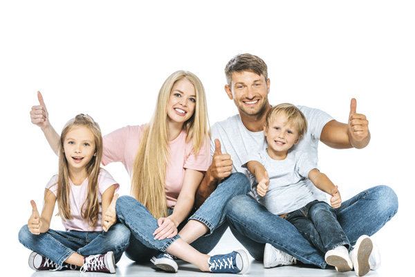 Junge, glückliche Familie lacht und hält die Daumen hoch