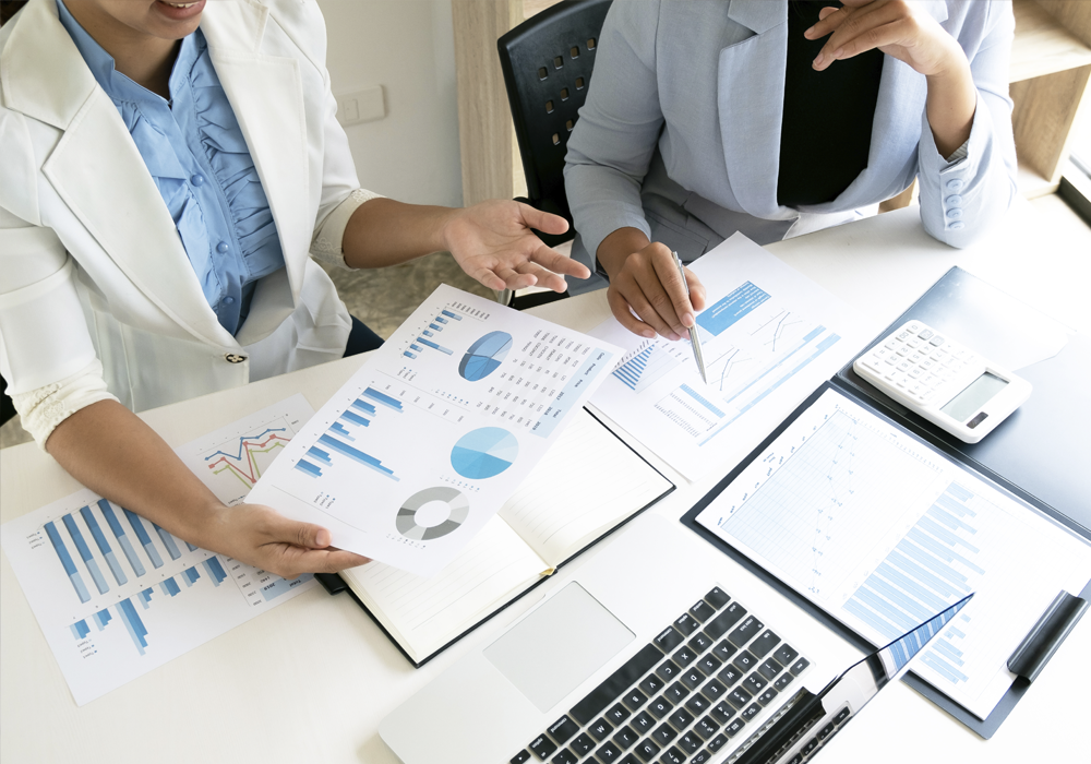 Personen Betrachten Statistiken, welche auf dem Tisch ausgebreitet sind